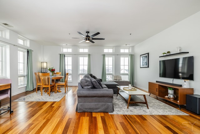 living room featuring ceiling fan, a wealth of natural light, and light hardwood / wood-style flooring