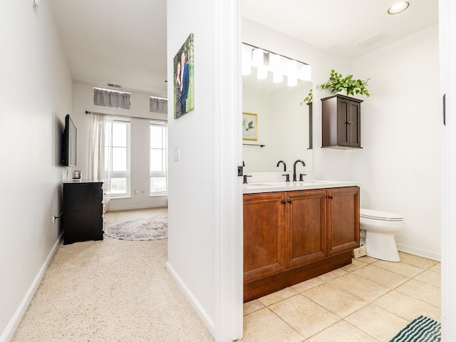 bathroom featuring toilet, tile patterned flooring, and vanity