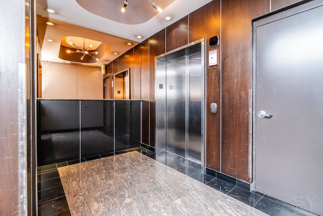 interior space featuring a tray ceiling and elevator