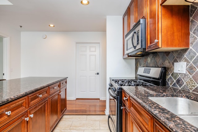 kitchen featuring dark stone counters, sink, tasteful backsplash, and stainless steel appliances