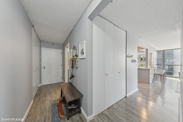 hall with light hardwood / wood-style flooring and a textured ceiling