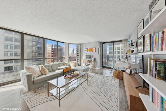 living room with a wall of windows, a textured ceiling, and hardwood / wood-style floors