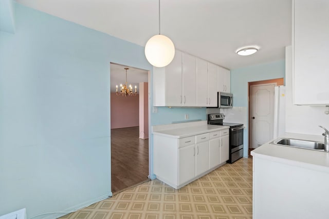 kitchen with light countertops, appliances with stainless steel finishes, a sink, and white cabinetry