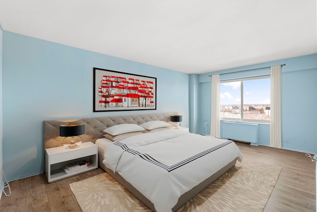 bedroom featuring light wood-style floors and radiator heating unit