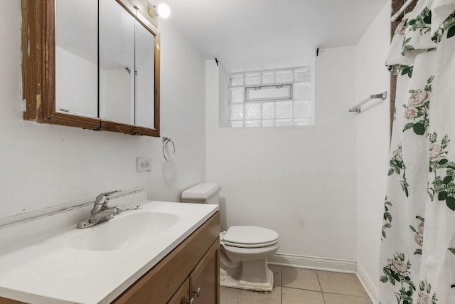 bathroom featuring tile patterned flooring, toilet, vanity, baseboards, and a shower with curtain