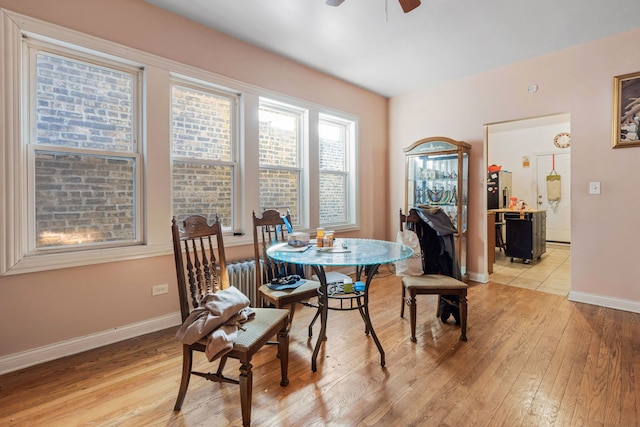 dining room with light wood-style floors, baseboards, and a ceiling fan