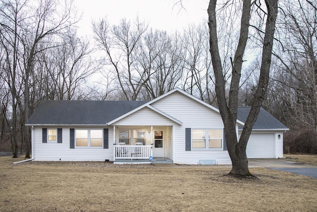 ranch-style home with roof with shingles, covered porch, an attached garage, a front yard, and driveway