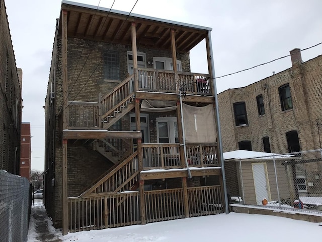 exterior space with fence, a balcony, and stairs