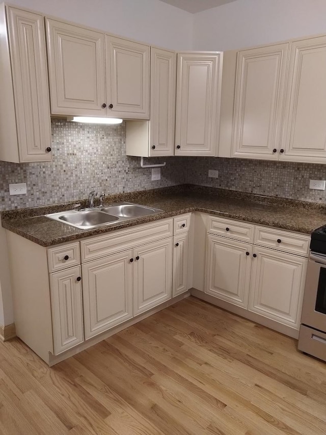 2921 N Kedzie Ave, Chicago, IL 60618 - kitchen with dark countertops, stainless steel range with electric stovetop, light wood-style flooring, and a sink