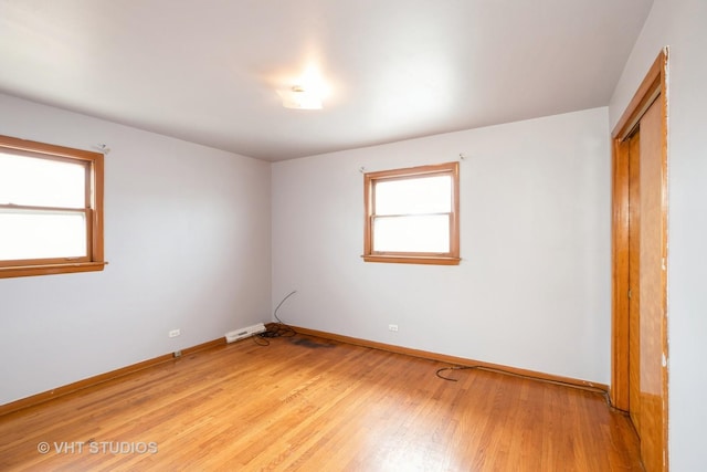 empty room featuring baseboards and light wood-type flooring