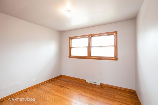 spare room with light wood-type flooring, baseboards, and visible vents