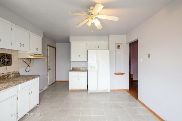 kitchen featuring ceiling fan, under cabinet range hood, white cabinetry, backsplash, and white refrigerator with ice dispenser