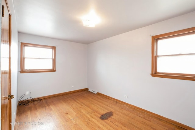 empty room featuring visible vents, baseboards, and light wood finished floors