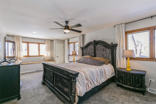 carpeted bedroom featuring a ceiling fan, visible vents, and baseboards