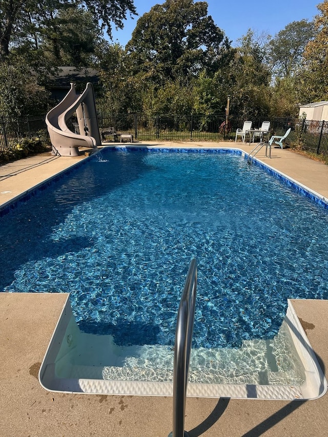 view of swimming pool featuring a fenced in pool, fence, and a water slide