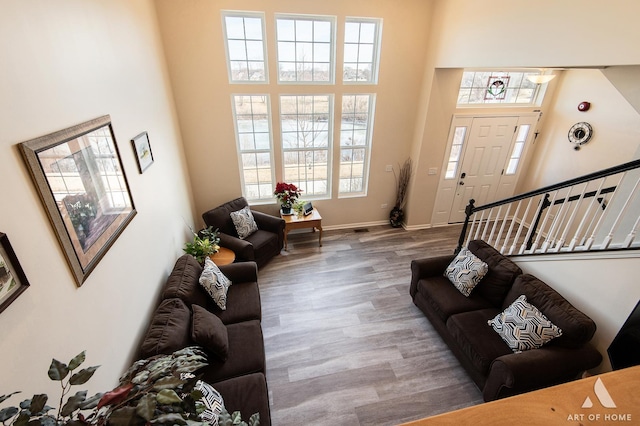 living room with hardwood / wood-style flooring and a towering ceiling