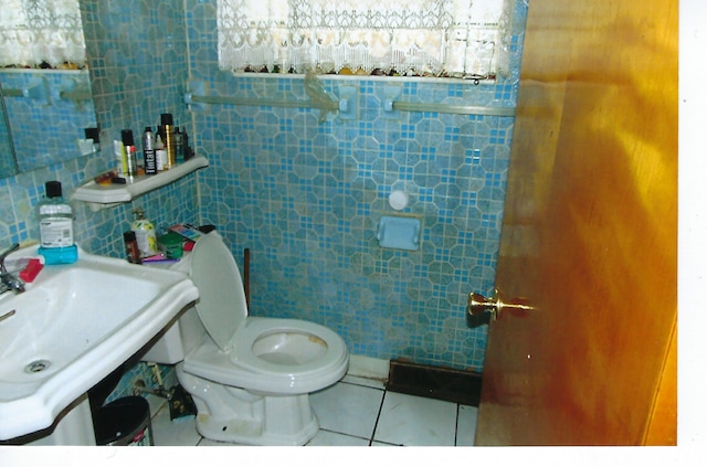 49 W 83rd St, Chicago, IL 60620 - bathroom featuring toilet, tile patterned flooring, tile walls, and a sink