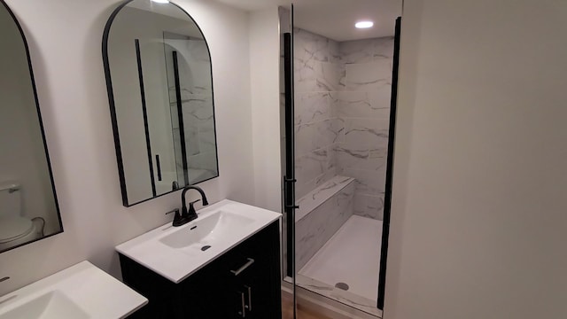 full bath with vanity and a marble finish shower