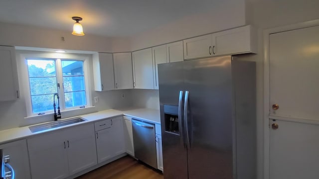 kitchen featuring light countertops, appliances with stainless steel finishes, a sink, and white cabinets