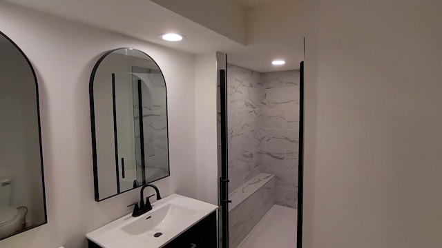 full bath featuring a marble finish shower, vanity, and recessed lighting