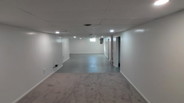 finished basement with visible vents, baseboards, and a drop ceiling