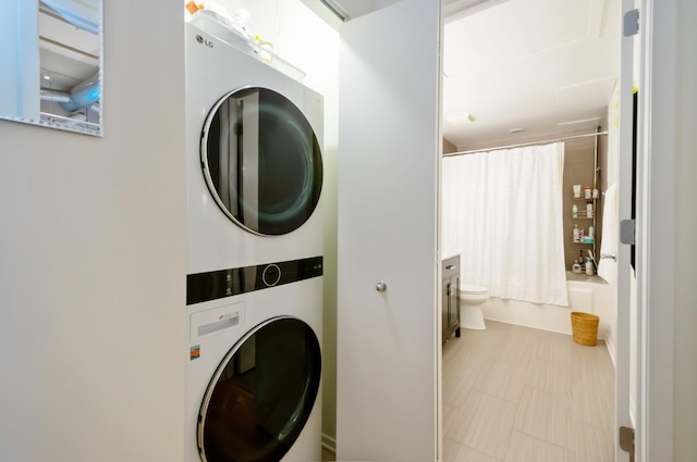 washroom featuring stacked washer / dryer and laundry area