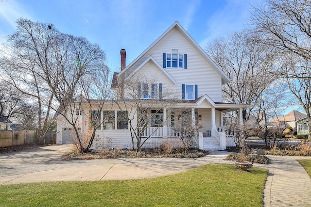 view of front of home featuring a chimney, fence, and a porch