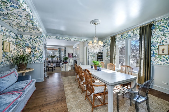 dining space featuring wallpapered walls, ornamental molding, and a wainscoted wall