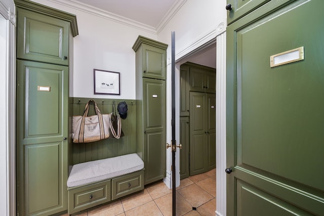 mudroom with light tile patterned floors, ornamental molding, and a wainscoted wall