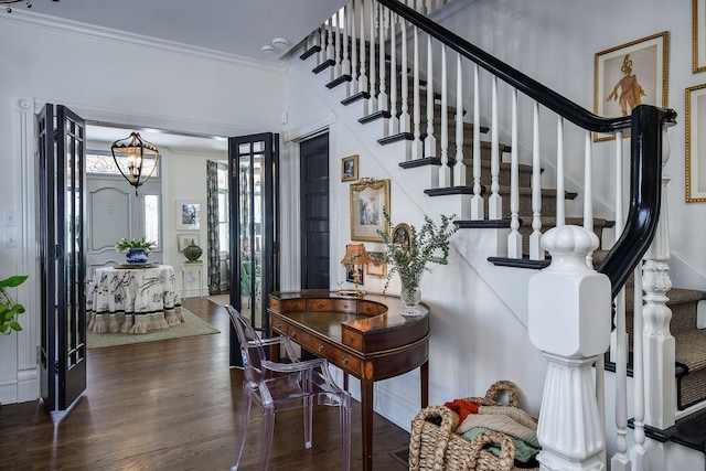 entrance foyer with ornamental molding, stairway, and wood finished floors