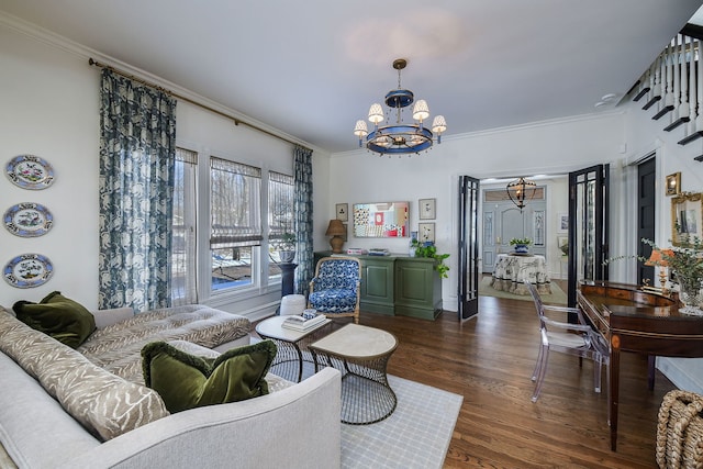 living area with ornamental molding, dark wood finished floors, and an inviting chandelier