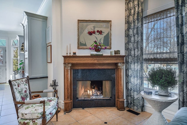 interior space with crown molding, a lit fireplace, and tile patterned floors