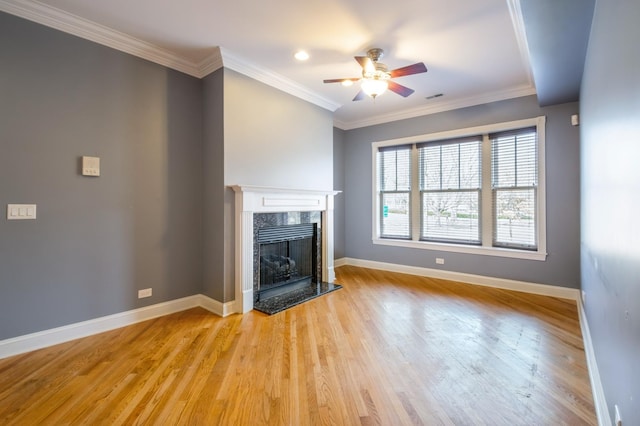 unfurnished living room with ornamental molding, light wood finished floors, a high end fireplace, and baseboards