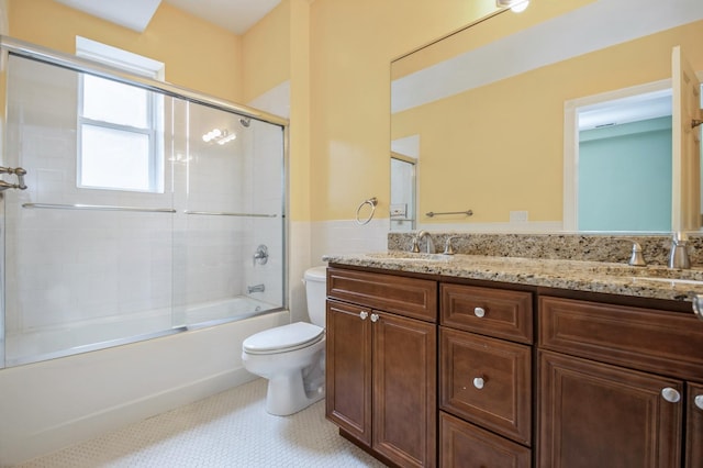 bathroom featuring enclosed tub / shower combo, a sink, toilet, and double vanity