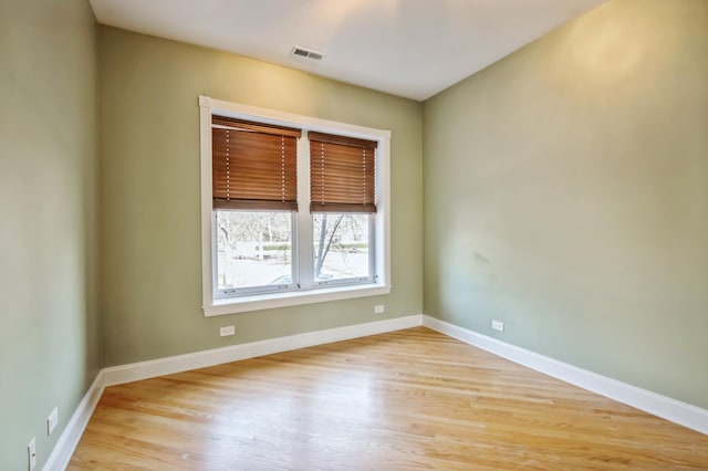 spare room with visible vents, light wood finished floors, and baseboards