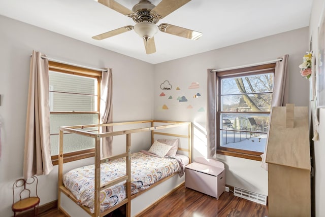 bedroom featuring baseboards, wood finished floors, visible vents, and a ceiling fan