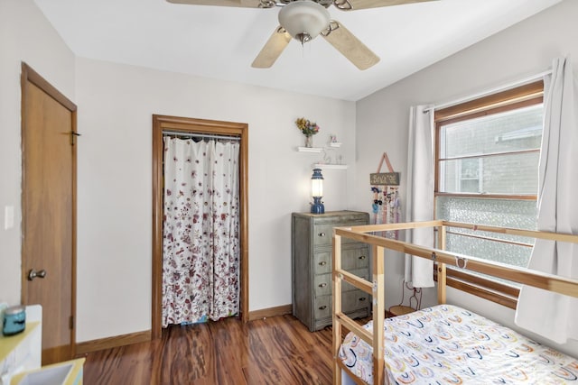 bedroom with a ceiling fan, baseboards, and wood finished floors