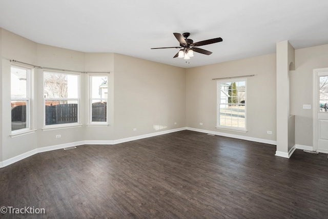 unfurnished living room featuring a ceiling fan, visible vents, dark wood-style floors, baseboards, and arched walkways