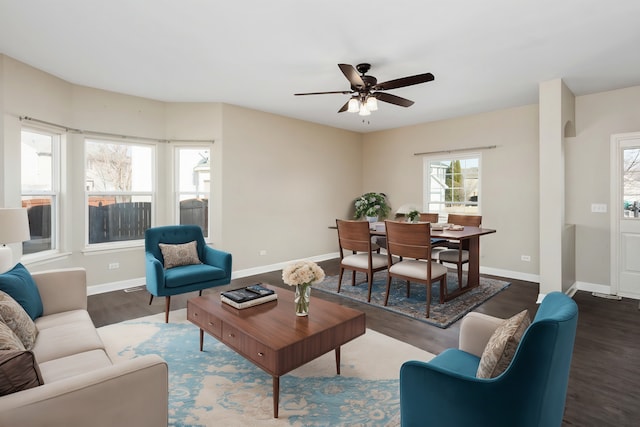 living room with arched walkways, a ceiling fan, baseboards, and wood finished floors