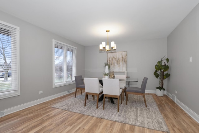 dining room with a chandelier and light hardwood / wood-style flooring