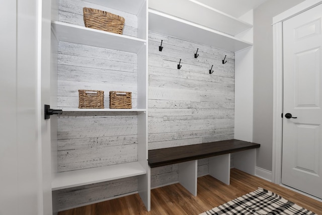 mudroom with hardwood / wood-style floors and wood walls