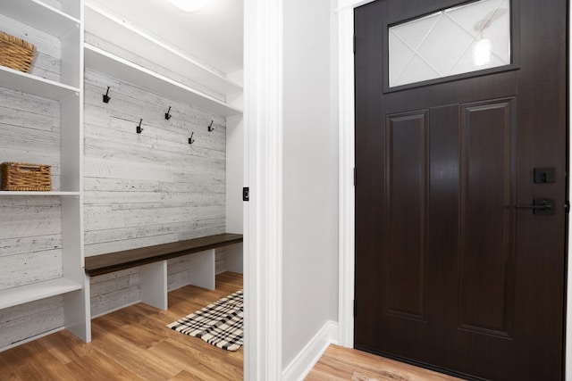 mudroom featuring light hardwood / wood-style flooring and wood walls