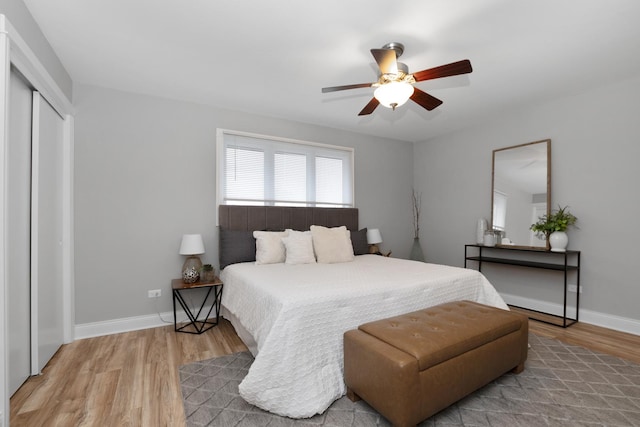 bedroom with hardwood / wood-style flooring, ceiling fan, and a closet