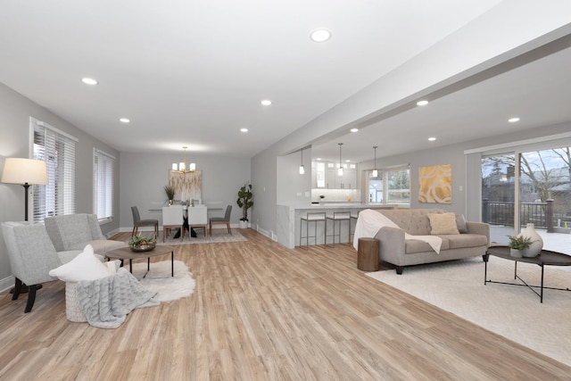 living room featuring an inviting chandelier and light hardwood / wood-style floors