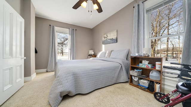 bedroom with vaulted ceiling, light colored carpet, and ceiling fan