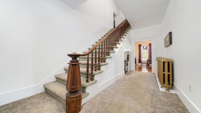 staircase featuring carpet flooring and radiator heating unit