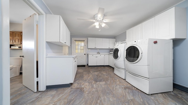 washroom with cabinets, washing machine and dryer, and ceiling fan