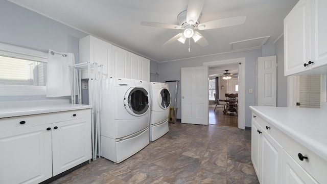 washroom featuring cabinets, a healthy amount of sunlight, and washer and clothes dryer