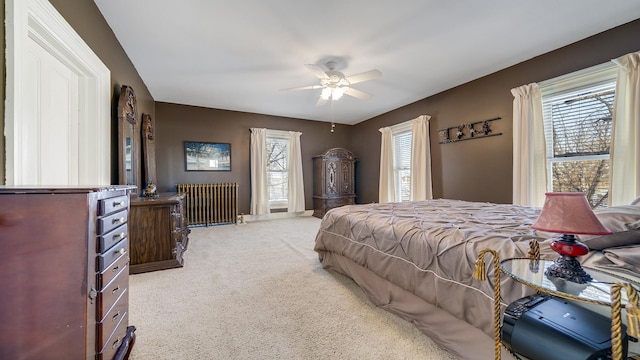 bedroom with radiator, light carpet, and ceiling fan