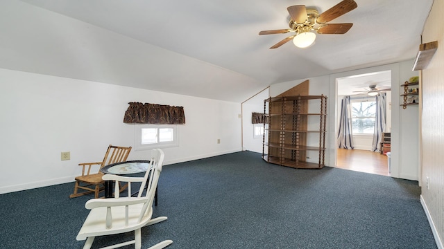 sitting room with vaulted ceiling, ceiling fan, and dark carpet